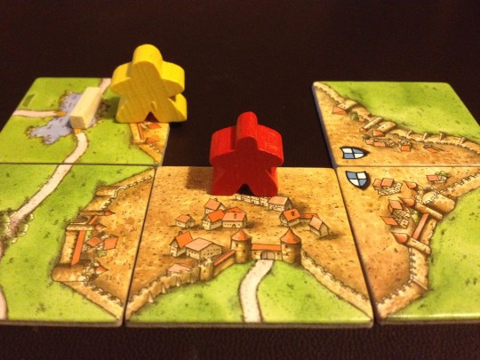 The Yellow player has played his large Meeple as a Knight in the hope of stealing the City, and points away from the Red player.