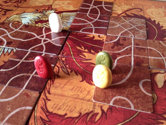 The Red, Green and White players all head towards the same tile space.